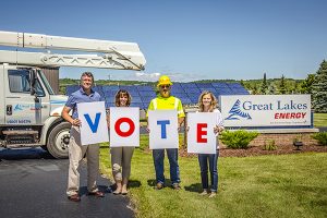 4 people holding signs that spell vote