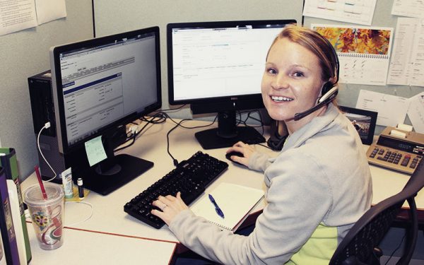 Woman with telephone headset working at a computer