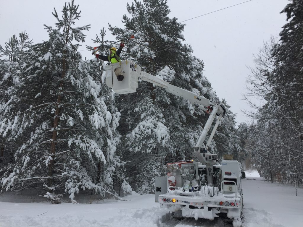 Bucket truck fixing power lines after snow storm