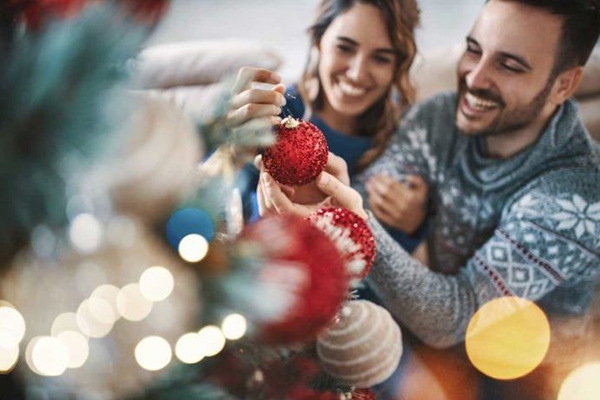 Couple decorating holiday tree