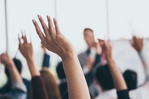 Raised hands at meeting to show involvement