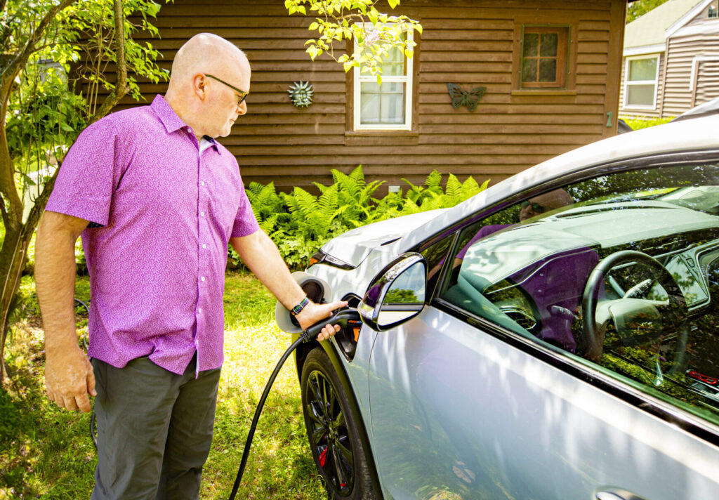 Man charging EV at home.