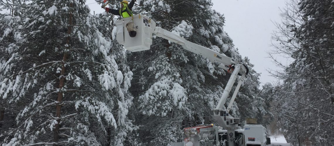 Bucket truck fixing power lines after snow storm