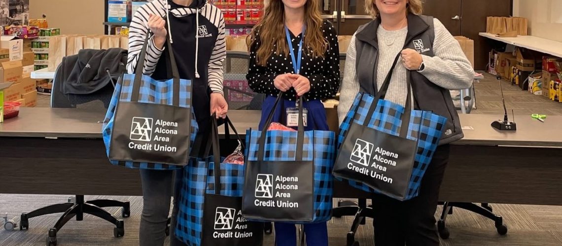 Alpena Alcona Area Credit Union employees pose for a picture with some of the donated items they provided for co-op crews working to restore power across Northern Michigan.