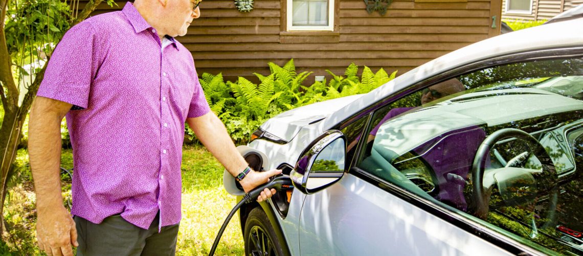 Man charging EV at home.