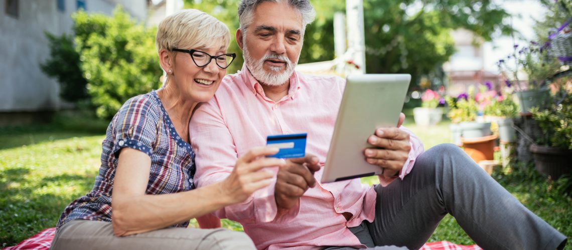 Elderly couple buying online with their card.