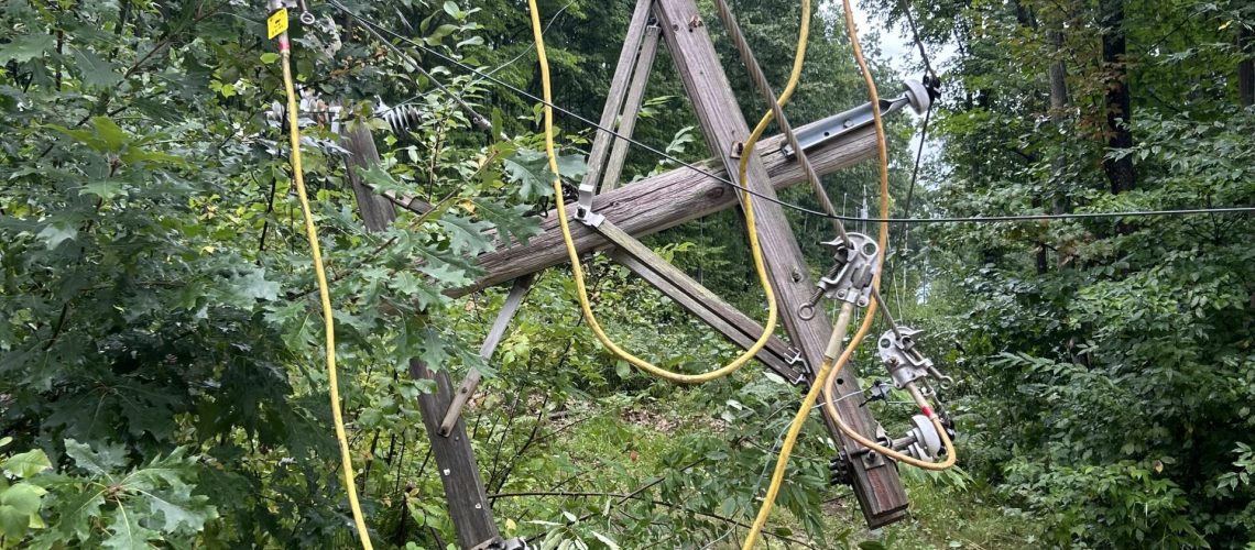 Broken pole with lines down due to storm damage.