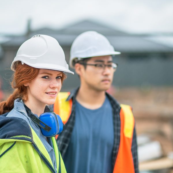 Building site workers outdoors, woman looking at camera portrait