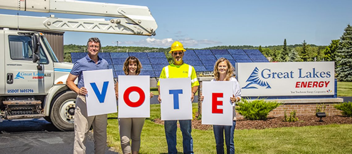 4 people holding signs that spell vote